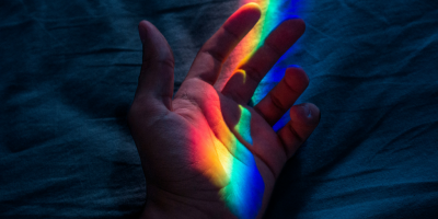 Hand with rainbow light shining on it